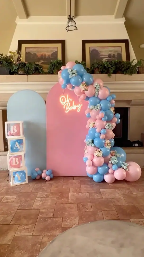 Balloon installation in soft pink and blue tones split across a photo wall
