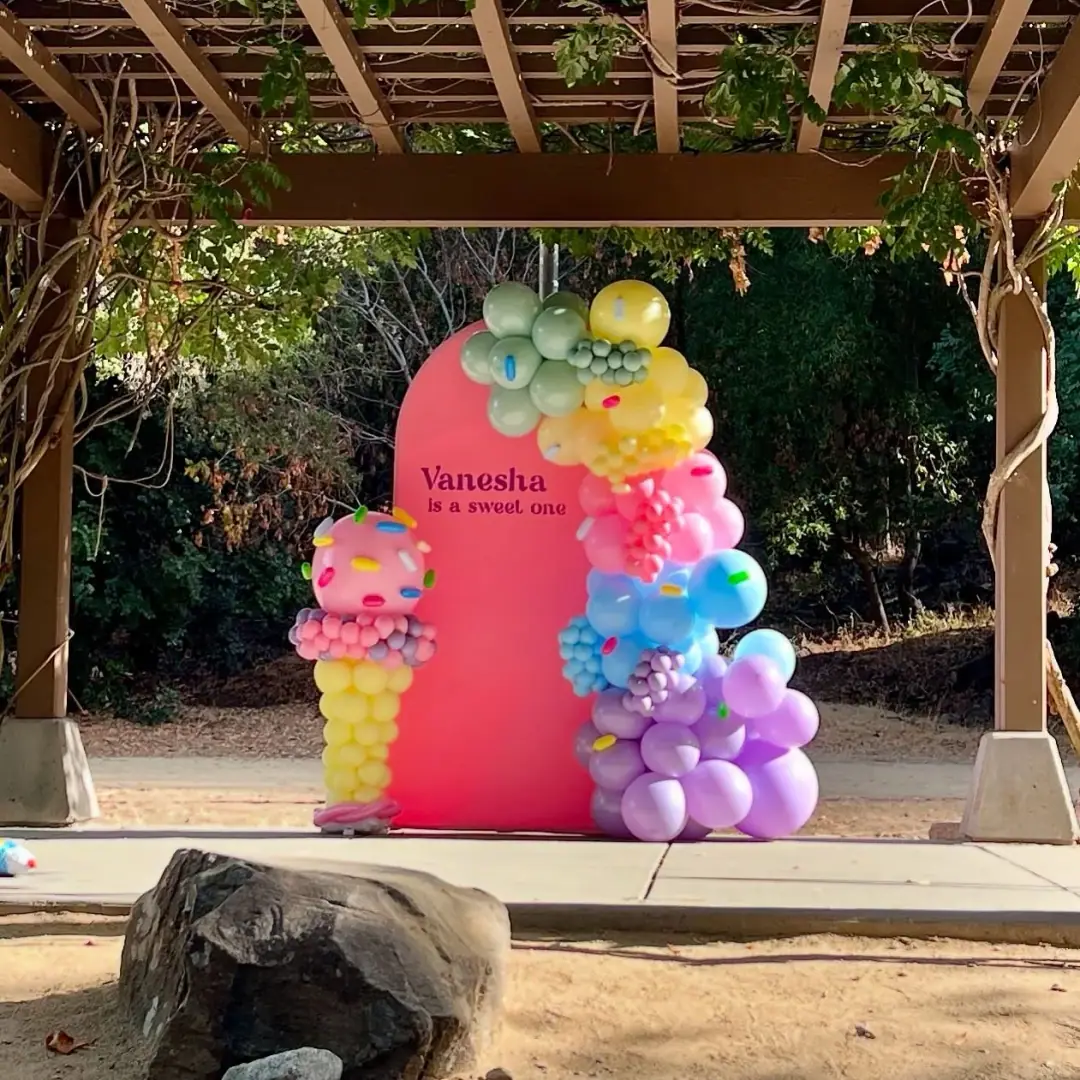 Balloon photo backdrop built behind a table for a child's birthday celebration