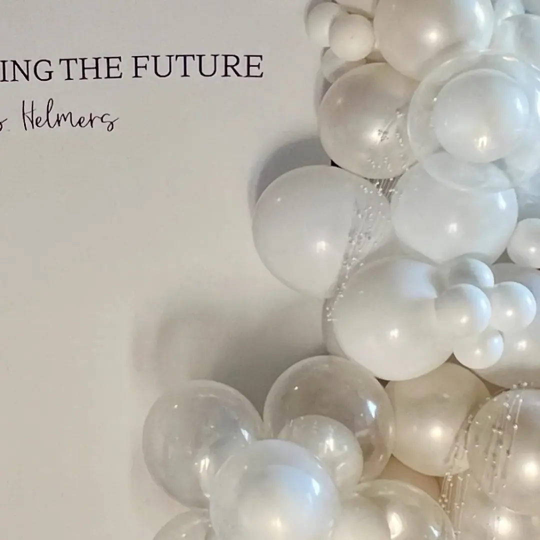 White and pearl balloon backdrop styled for an elegant celebration
