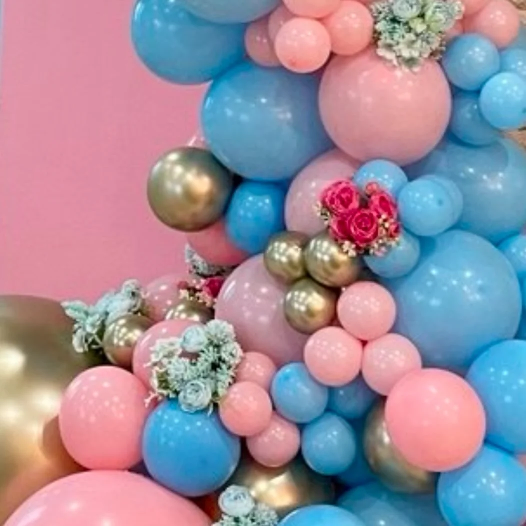 Soft pink and blue balloon garland with a backdrop, styled for a gender reveal celebration