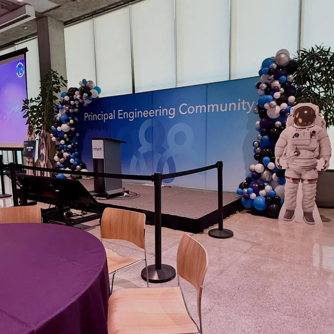 Twin balloon towers framing a corporate stage at an engineering community event