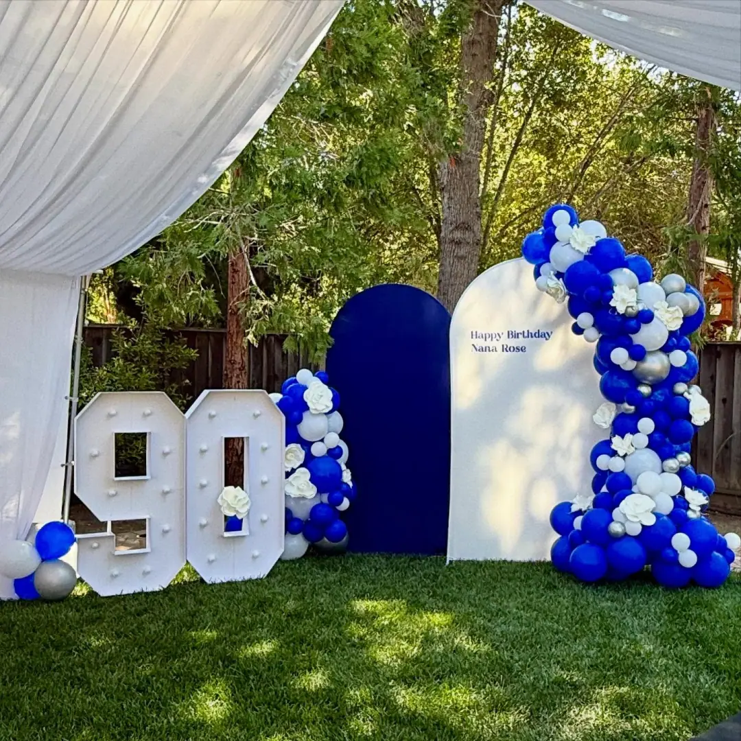 Wide balloon garland paired with a backdrop and marquee letters